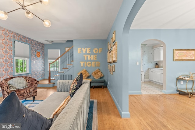 119 Burke, Towson, MD 21286 - living room featuring arched walkways, wallpapered walls, stairway, baseboards, and light wood-style floors