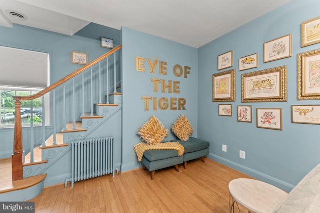 119 Burke, Towson, MD 21286 - sitting room featuring radiator heating unit, wood finished floors, stairs, and baseboards
