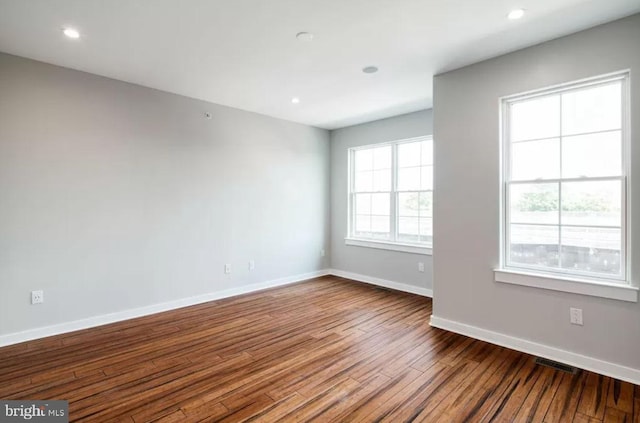 unfurnished room featuring dark wood finished floors, baseboards, and recessed lighting
