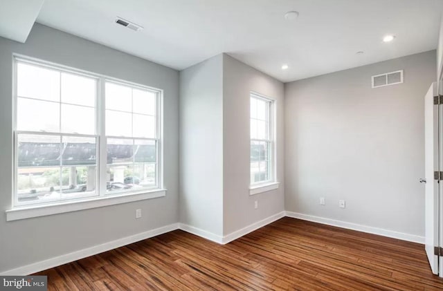 spare room with baseboards, dark wood-style flooring, and recessed lighting
