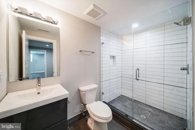 full bath with toilet, vanity, and a shower stall