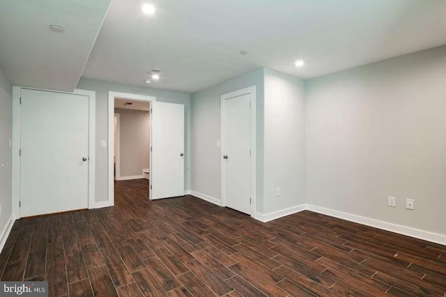 below grade area featuring dark wood finished floors, baseboards, and recessed lighting