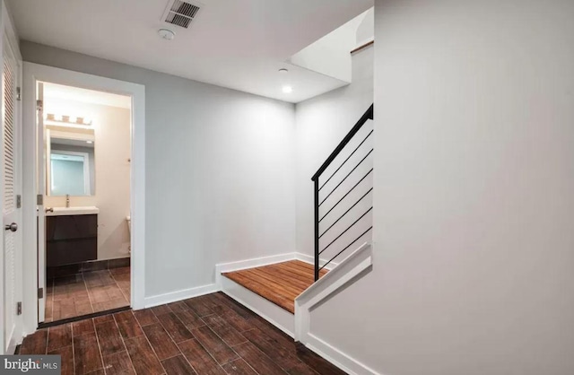 mudroom with baseboards, dark wood-type flooring, a sink, and recessed lighting