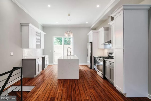 kitchen with appliances with stainless steel finishes, a sink, an island with sink, tasteful backsplash, and recessed lighting