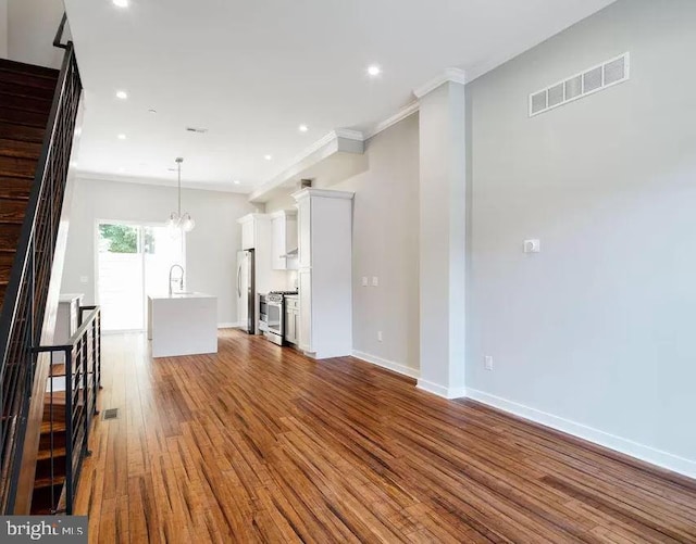 unfurnished living room with crown molding, dark wood-type flooring, a sink, baseboards, and recessed lighting