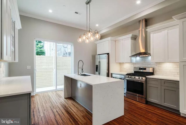 kitchen featuring stainless steel appliances, a sink, wall chimney exhaust hood, tasteful backsplash, and light countertops
