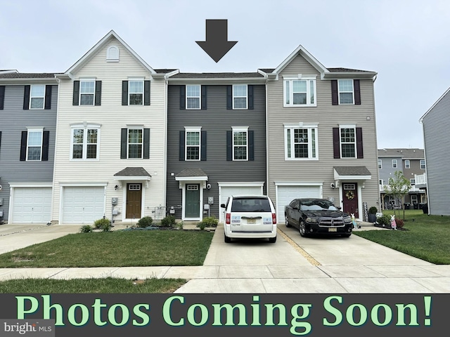 townhome / multi-family property with driveway, a garage, and a front lawn