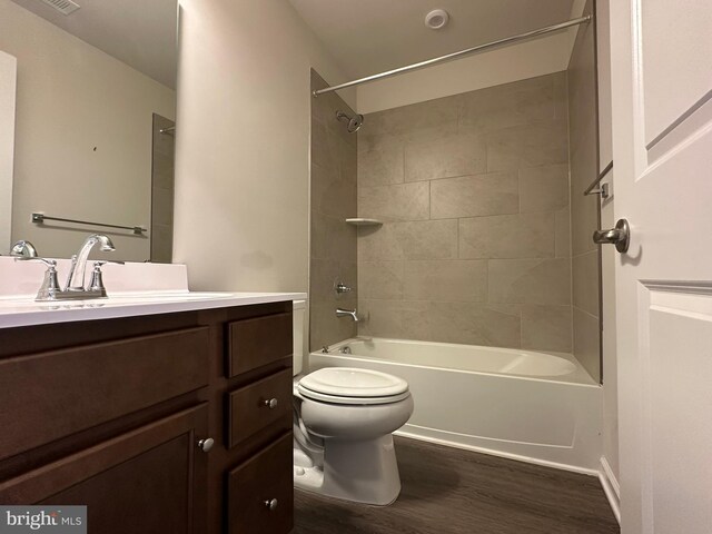 full bathroom featuring wood finished floors, toilet, vanity, and shower / washtub combination