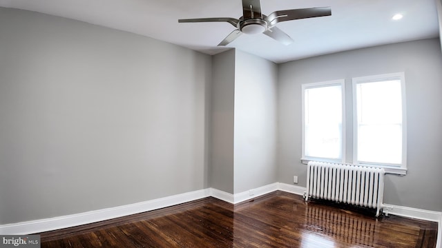 empty room featuring radiator, baseboards, wood finished floors, a ceiling fan, and recessed lighting