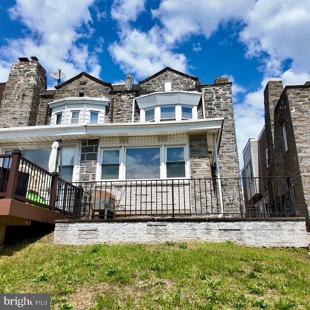 back of house with stone siding