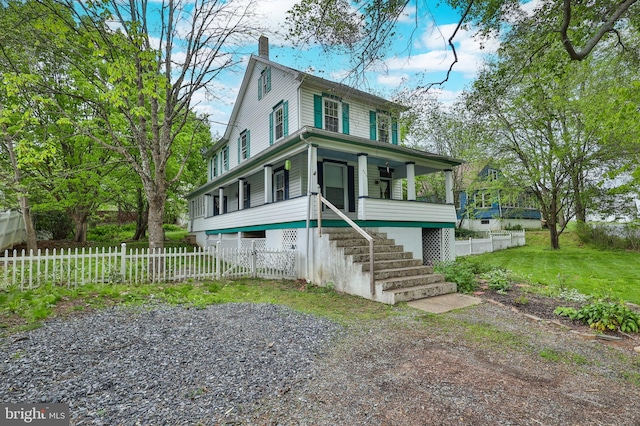 view of front of house featuring a chimney, covered porch, stairway, and a fenced front yard