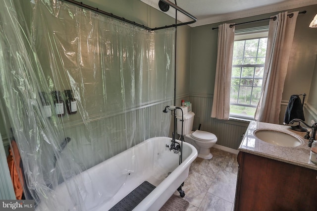 full bath with a freestanding bath, healthy amount of natural light, toilet, vanity, and a wainscoted wall