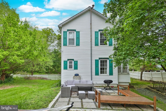 back of property with an outdoor living space and a patio area