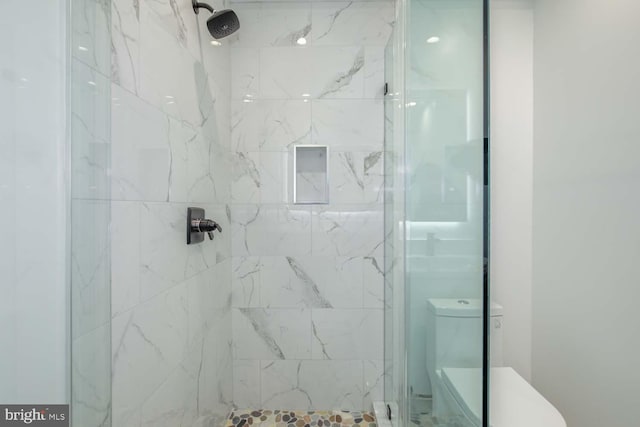 bathroom with a shower stall and toilet
