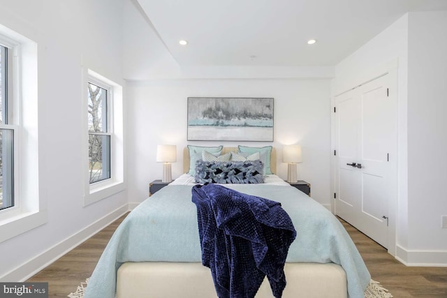 bedroom with wood finished floors, baseboards, and recessed lighting
