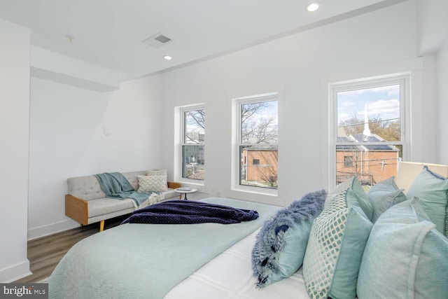 bedroom with wood finished floors, baseboards, and recessed lighting