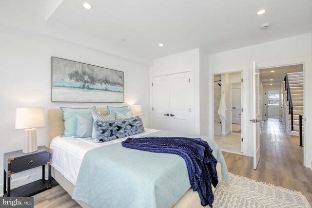bedroom with a closet, wood finished floors, and recessed lighting