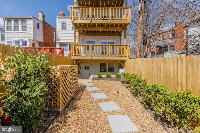 rear view of house featuring fence and a balcony