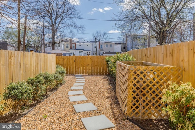 view of yard featuring fence, a residential view, and a gate