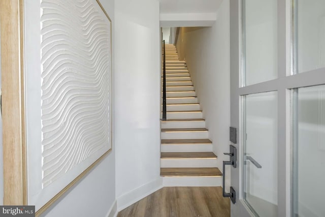 stairway featuring wood finished floors and baseboards