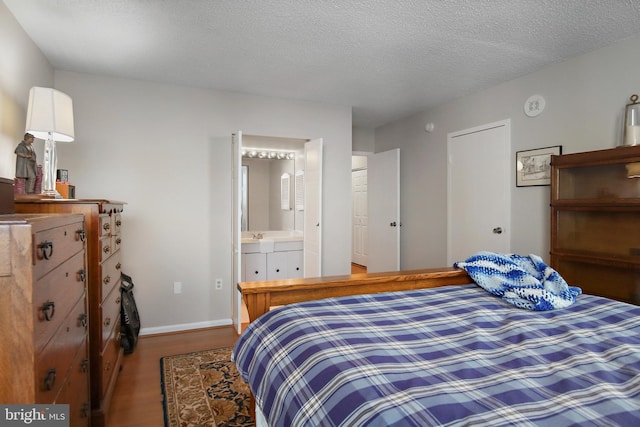 205 E Joppa Rd Unit 608, Towson, MD 21286 - bedroom with wood finished floors, baseboards, ensuite bath, a textured ceiling, and a sink