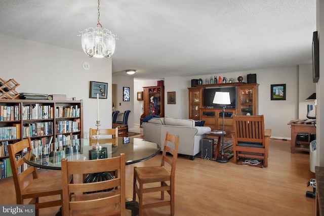 205 E Joppa Rd Unit 608, Towson, MD 21286 - dining area featuring light wood-type flooring, a textured ceiling, and a chandelier