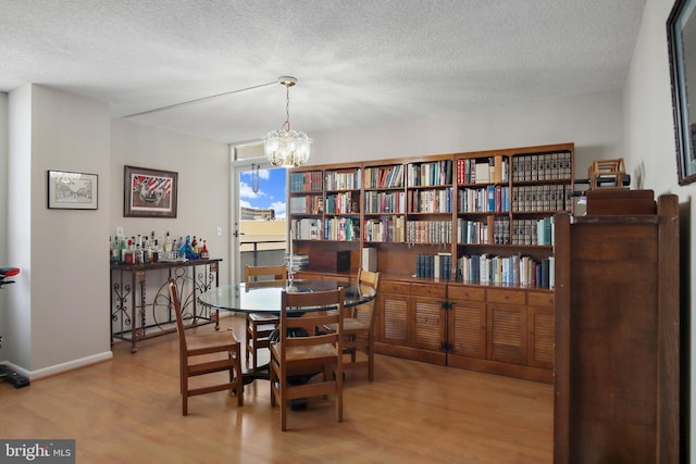 205 E Joppa Rd Unit 608, Towson, MD 21286 - dining space with wood finished floors, a textured ceiling, a chandelier, and baseboards