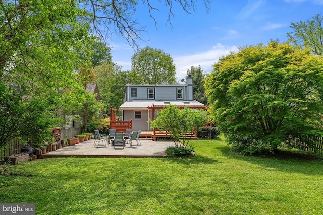 back of property with a patio area, a chimney, and a deck