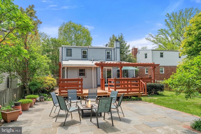 rear view of property with a pergola, outdoor dining area, a deck, a patio area, and a chimney
