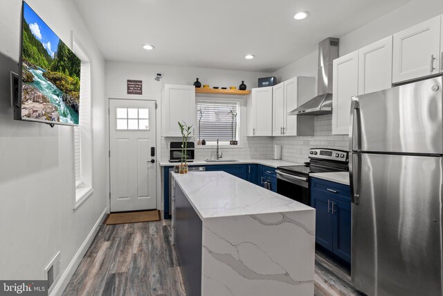 1807 N 27th St, Philadelphia, PA 19121 - kitchen featuring stainless steel appliances, wall chimney range hood, blue cabinets, dark wood finished floors, and recessed lighting