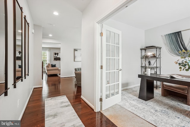 hallway with wood finished floors, a desk, recessed lighting, and baseboards