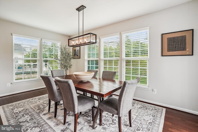 dining space featuring a chandelier, wood finished floors, and baseboards