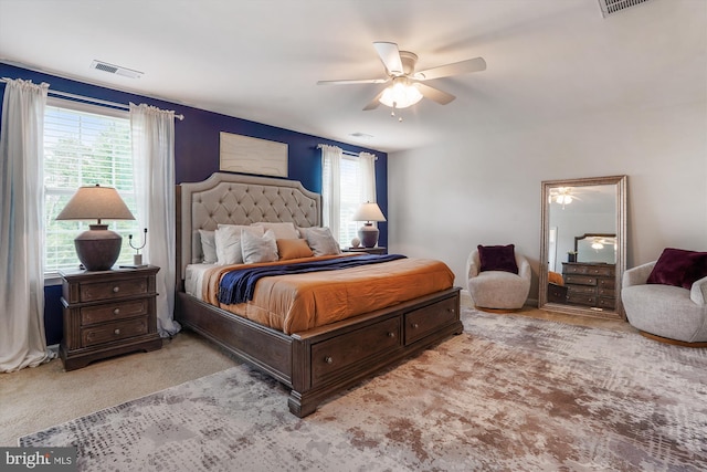 carpeted bedroom featuring multiple windows and a ceiling fan