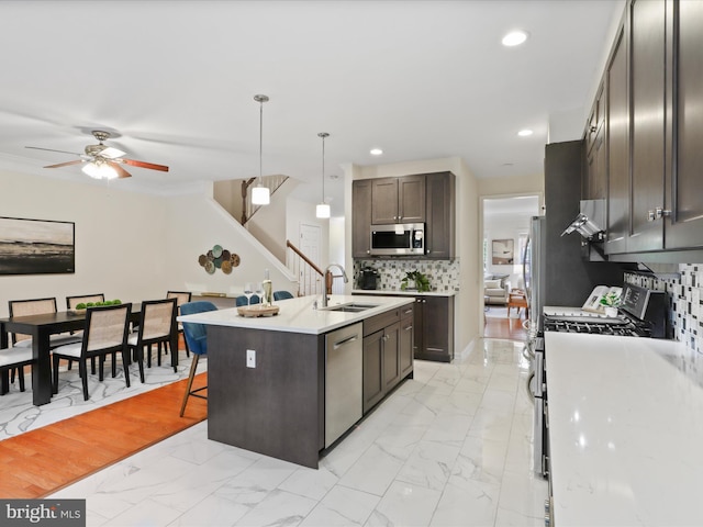 kitchen with stainless steel appliances, a sink, light marble finish flooring, a ceiling fan, and recessed lighting