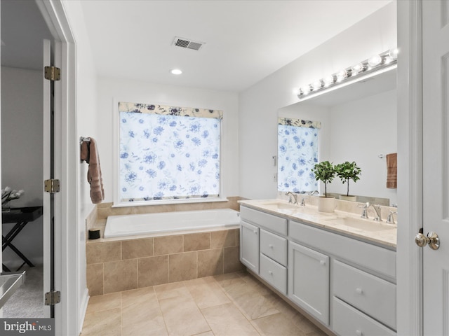bathroom featuring a garden tub, double vanity, and tile patterned flooring