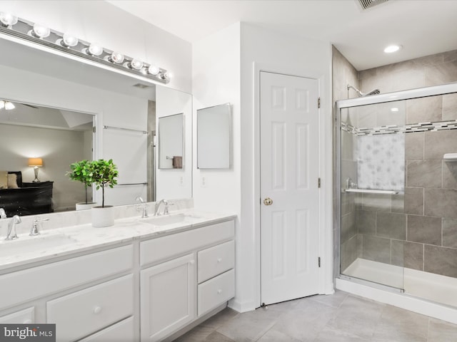 bathroom with a stall shower, tile patterned floors, and double vanity