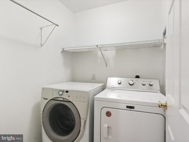 clothes washing area with washing machine and dryer