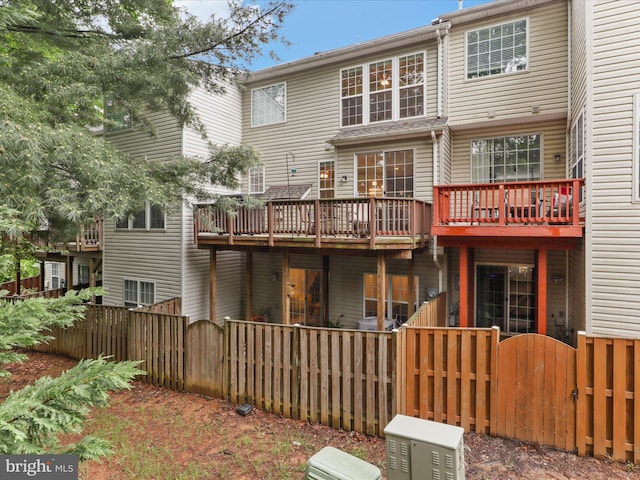 back of house featuring a gate and a wooden deck