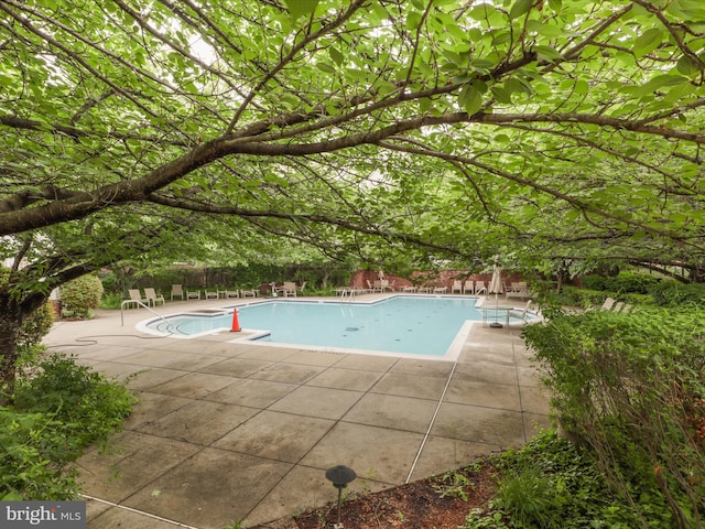 community pool featuring a patio area and fence