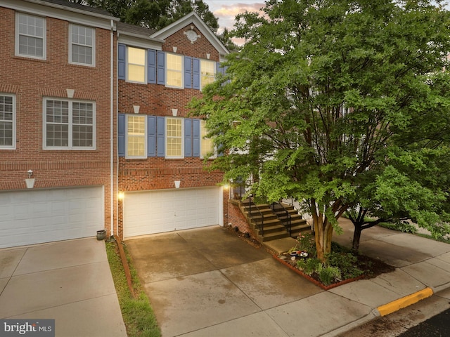 view of front of property with brick siding, an attached garage, and concrete driveway