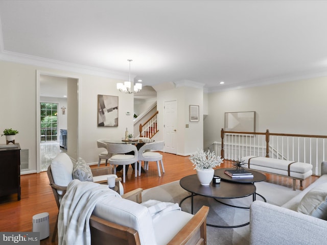 living area featuring stairs, a chandelier, crown molding, wood finished floors, and recessed lighting