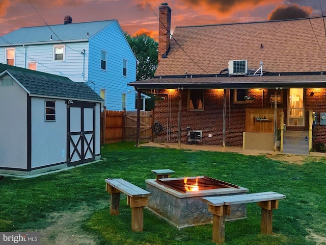 1918 Maxwell Ave, Baltimore, MD 21222 - rear view of house featuring central air condition unit, a shed, a fire pit, an outdoor structure, and brick siding