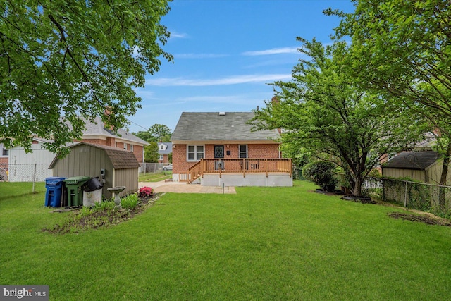 rear view of house featuring a shed, an outbuilding, brick siding, a wooden deck, and a patio