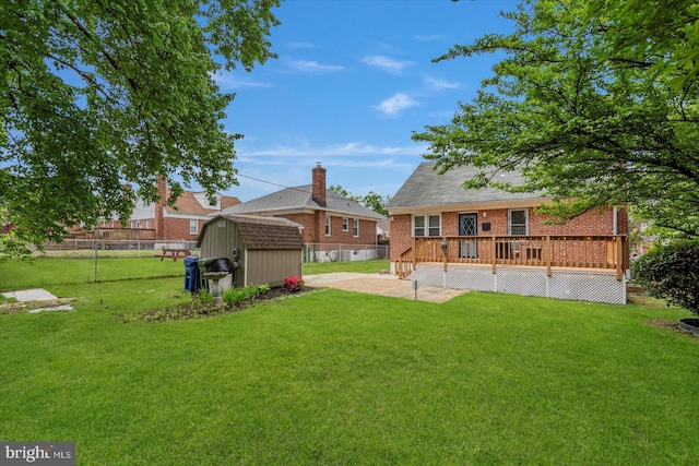 rear view of house featuring a storage shed, an outdoor structure, a wooden deck, brick siding, and a patio area