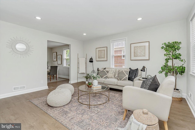 living room featuring wood finished floors, baseboards, and recessed lighting
