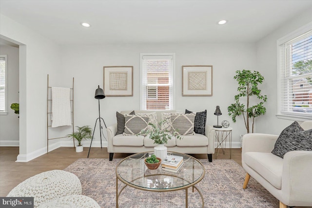 living room with wood finished floors, baseboards, and recessed lighting