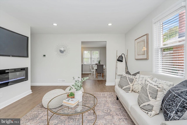 living area with wood finished floors, baseboards, and recessed lighting