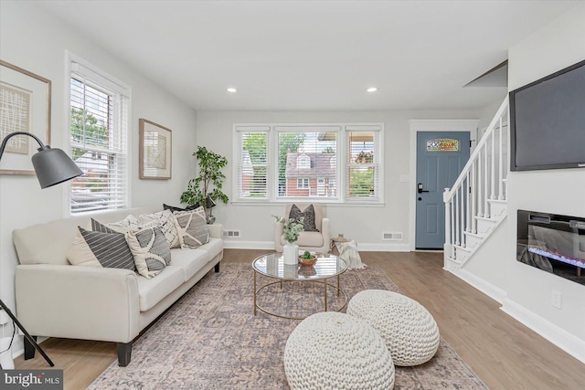living room featuring healthy amount of natural light, wood finished floors, baseboards, and recessed lighting