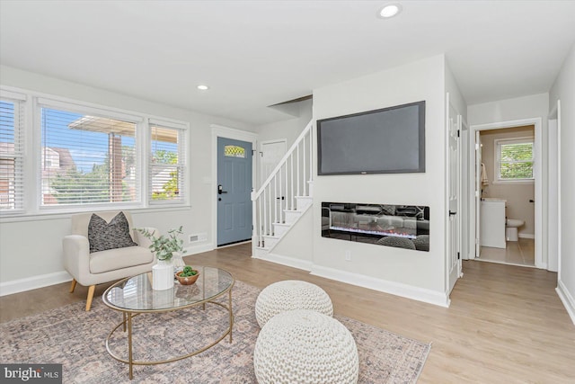 living area with stairs, light wood finished floors, baseboards, and recessed lighting