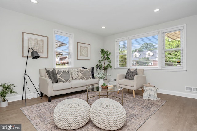 living room featuring healthy amount of natural light, baseboards, wood finished floors, and recessed lighting